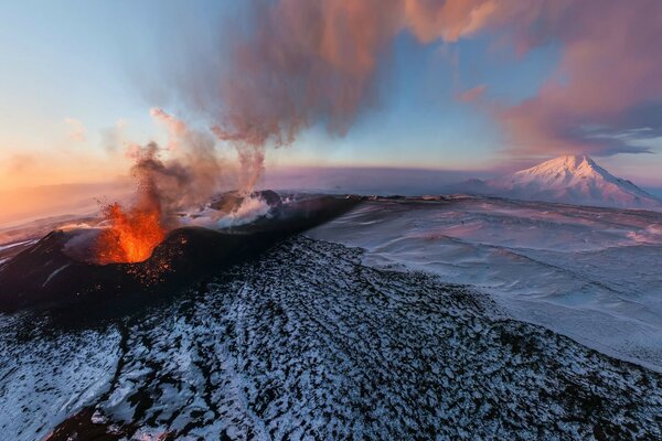 Erupción volcánica en las montañas cubiertas de nieve