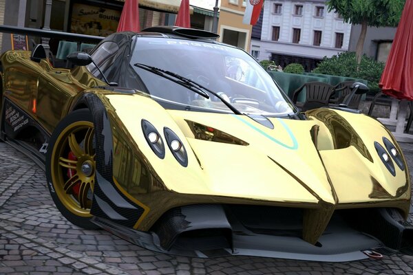 A golden-colored racing car near a cafe