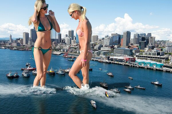 Two beautiful girls in swimsuits against the background of the sea with boats and a built-up coast