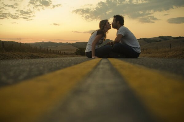 Couple d amoureux assis sur la route