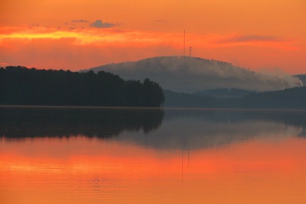 Orange Sonnenuntergang am See in den Bergen