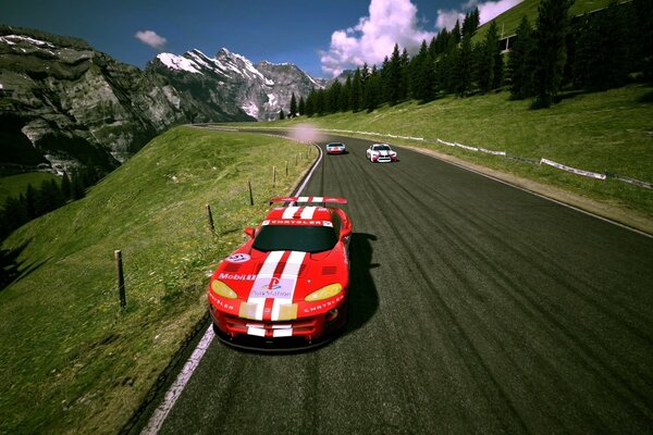 A red sports car on the road in the mountains