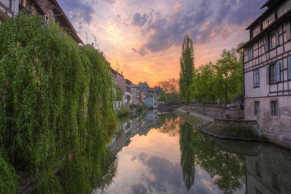 A canal in the city between houses at sunset