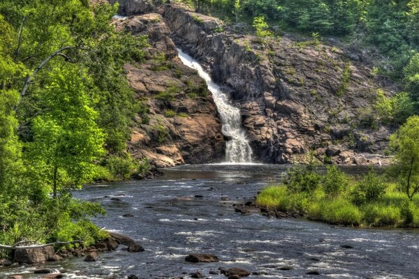 Der Wasserfall mündet mitten im Wald in einen Bergfluss