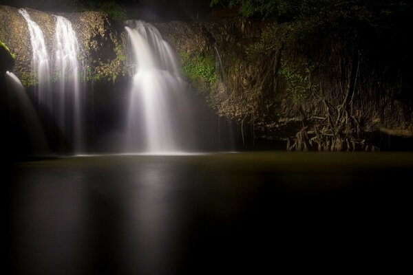 Landscape waterfall flowing into the river at night