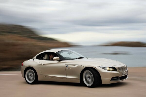 Beige sports car driving on the road very fast