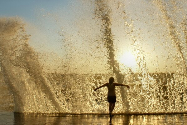 Mann läuft am Strand herum und spritzt in der Nähe