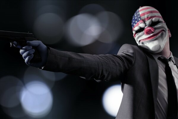 A man with a gun and a mask with the symbols of the USA on his face