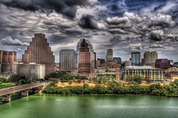 Dark sky over a big city, river and bridge