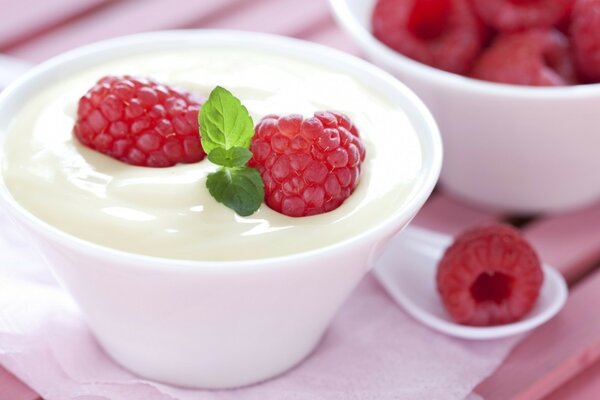 Eine Tasse cremiges Dessert mit Himbeeren