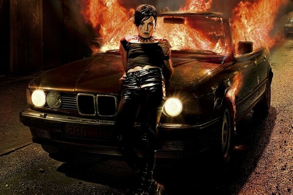 A girl on the background of a burning car