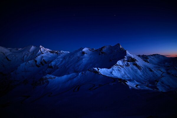 Paysage de montagnes enneigées dans la pénombre