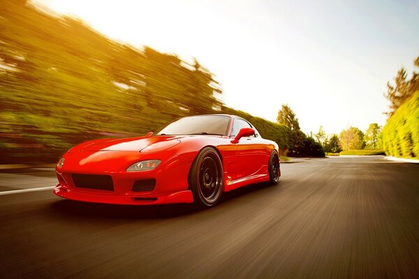 A red racing car is racing down the road