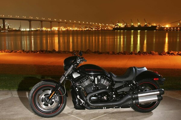 Motocicleta preta no fundo da cidade noturna