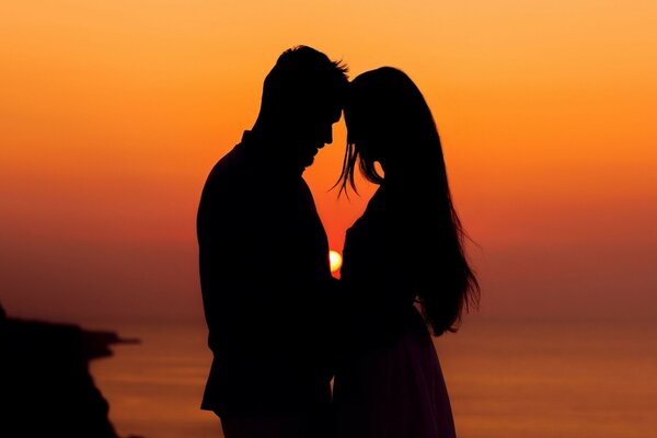 Pareja de enamorados al atardecer junto al mar