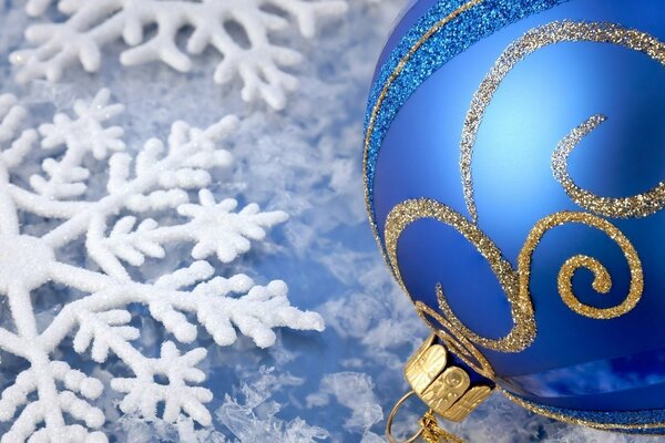 Bola de juguete azul de Navidad sobre fondo helado