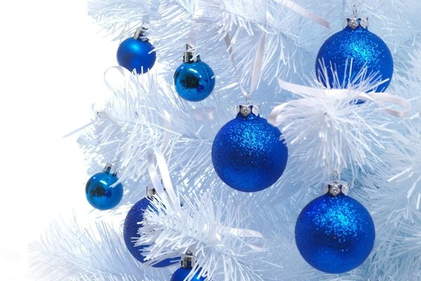 Schneeweißer Weihnachtsbaum mit blauen Spielsachen