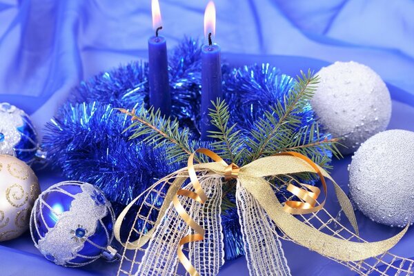 Zwei blaue Kerzen und Weihnachtsschmuck