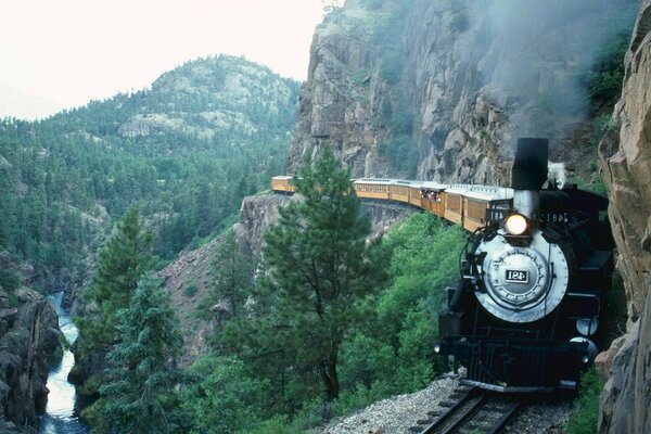 A train rides against the backdrop of a beautiful landscape of mountains