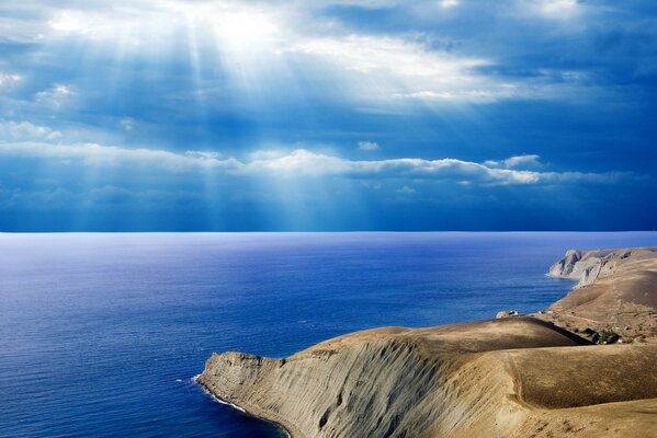 Los rayos del sol se abren paso a través de las nubes sobre el mar