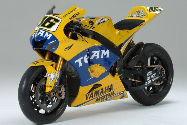 A yellow Yamaha motorcycle is on the floor