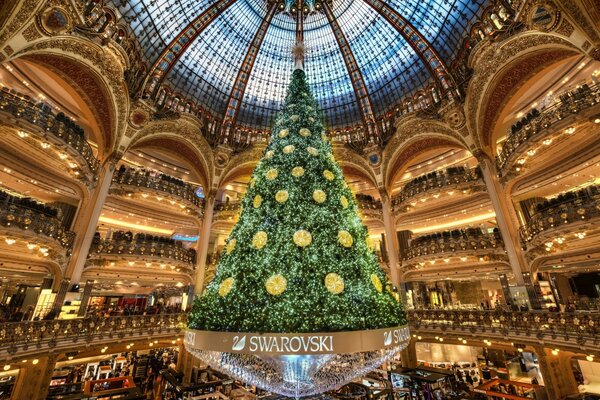 Sala con un gran árbol de Navidad en el centro