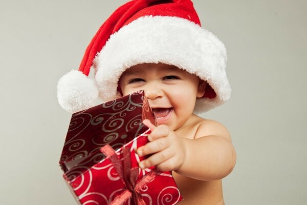 Niño con sombrero de Navidad con regalo