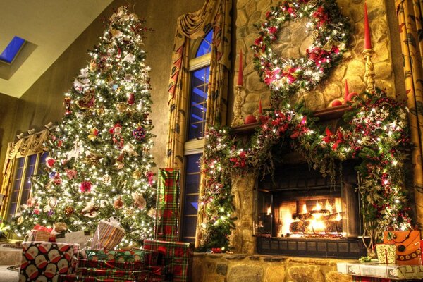 Christmas decoration of the house with a fireplace and a tall Christmas tree in toys