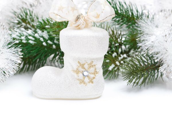 White stocking with a bow on a background of green needles