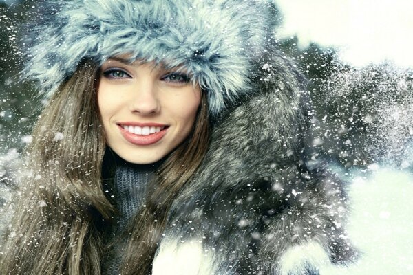 Smiling girl in flakes of snow