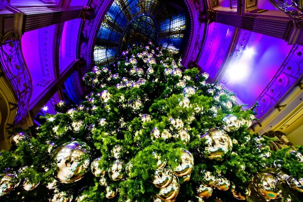 Foto de un árbol de Navidad decorado con bolas de oro desde abajo