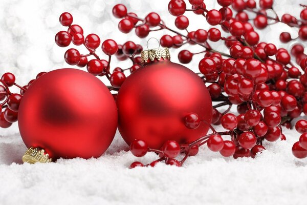 Red Christmas balls on a background of red berries