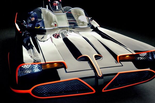 Powerful sports car with orange headlights on a dark background