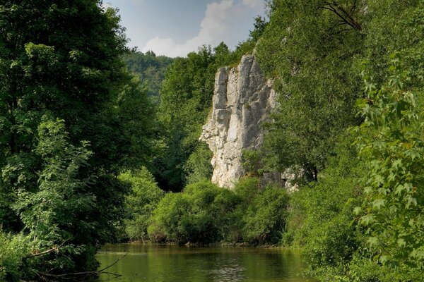 Lago fatato tra rocce e alberi