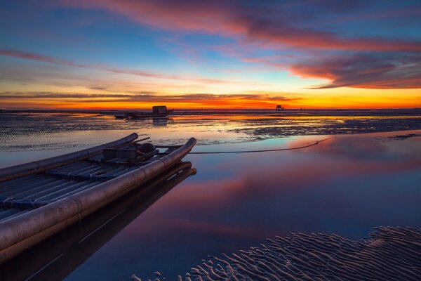 Berth near the smooth surface of the lake at sunset