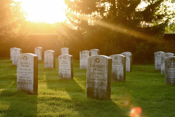 Die Sonne beleuchtet die Gräber auf dem Friedhof