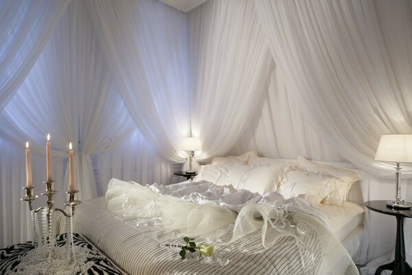 Chambre dans un style romantique: soie, fleurs, bougies