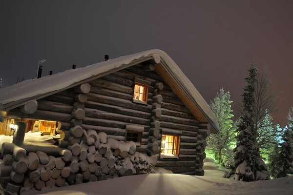 Casa de campo de madera en invierno bajo la nieve