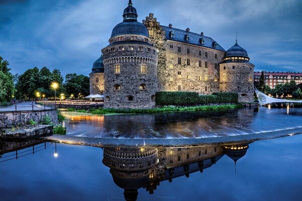 Belo castelo noturno perto da água