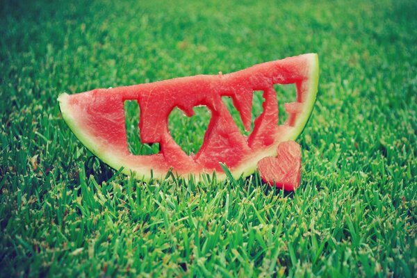 A piece of watermelon on green grass