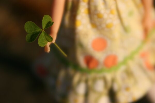 The hand holds a green plant