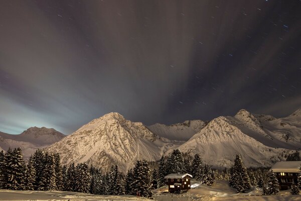 Winter forest with mountains. houses near the mountains. winter landscape