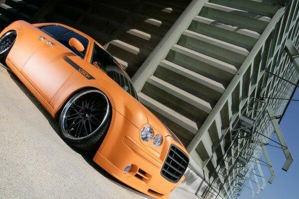 Orange premium car on the background of a concrete building