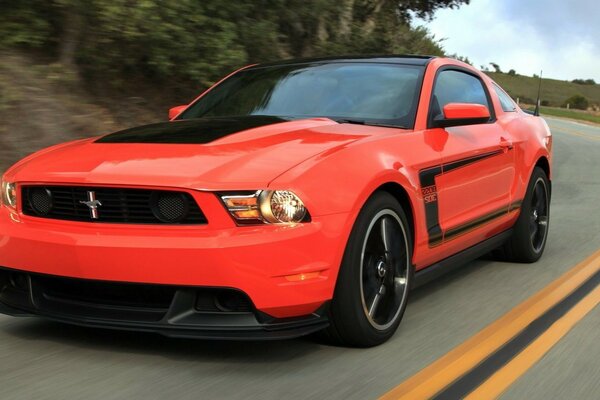 Un coche deportivo rojo corre por una pista de montaña