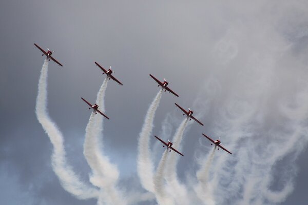 Military aircraft perform aerobatics in the sky