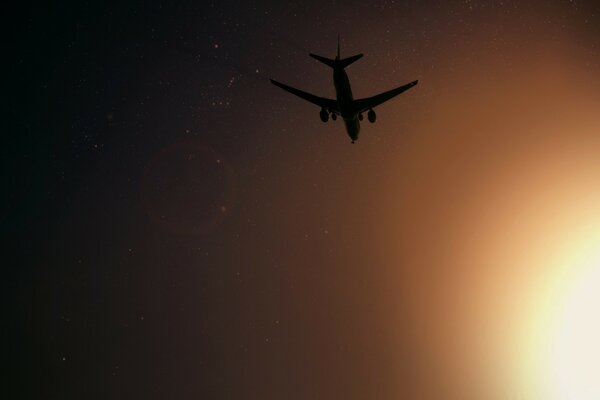 Flugzeug, das in einem hellen Sonnenuntergang abfährt