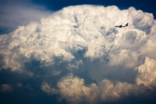 Un aereo che vola oltre le nuvole bianche