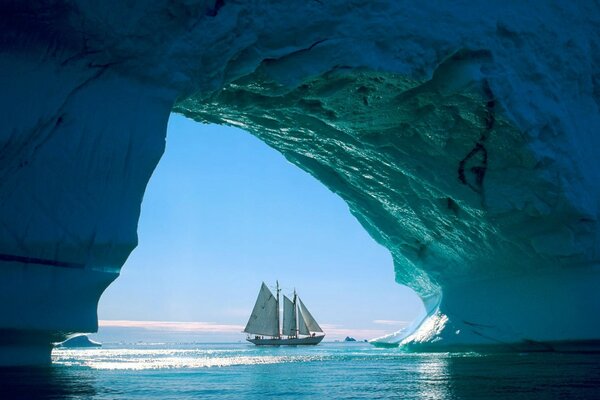 Sailboat in the ocean under the arches of the rocks