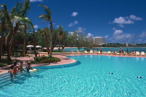 People are sitting on the edge of the pool