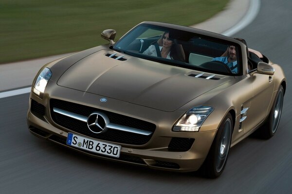 Golden Mercedes convertible with passengers on the highway